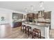 Modern kitchen boasts wood floors, granite countertops, and a large island with barstool seating at 8715 Gladden Hill Ln, Fort Mill, SC 29715