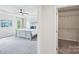 View of this main bedroom leading into the closet; features a tray ceiling, neutral decor, and lots of natural light at 8715 Gladden Hill Ln, Fort Mill, SC 29715