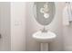 Stylish powder room featuring a modern pedestal sink, decorative mirror and towel rack at 101 Glencroft Dr, Wingate, NC 28174
