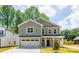 Charming two-story home featuring a two-car garage, gray siding, and a beautifully landscaped front yard at 1032 Dooley Dr, Charlotte, NC 28227