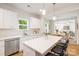 Spacious kitchen featuring white cabinetry, stainless steel appliances, and a central island with bar stools at 1032 Dooley Dr, Charlotte, NC 28227