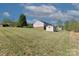 Expansive backyard featuring a gentle slope, an outbuilding, and partial view of the home's exterior at 106 Zurich Ln, Statesville, NC 28625