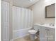 Bathroom featuring a shower and tub with a white shower curtain, toilet and vanity with mirror at 106 Zurich Ln, Statesville, NC 28625