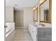 Bright bathroom featuring double vanity, gold trimmed mirrors, tile flooring and separate tub and shower at 106 Zurich Ln, Statesville, NC 28625
