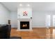 Living room featuring a fireplace with white mantle and marble surround, wood floors, and bright natural light at 106 Zurich Ln, Statesville, NC 28625