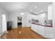 Open kitchen with white cabinetry, stainless steel appliances, and hardwood floors at 106 Zurich Ln, Statesville, NC 28625