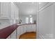 Bright kitchen featuring white cabinetry, burgundy countertops, and hardwood flooring at 106 Zurich Ln, Statesville, NC 28625