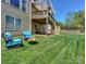 Expansive backyard with well-maintained lawn, fire pit, and wooden deck offering an ideal outdoor living space at 10643 Rippling Stream Nw Dr, Concord, NC 28027