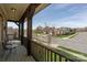 Covered balcony with wood railings and furniture overlooking a peaceful neighborhood street at 10643 Rippling Stream Nw Dr, Concord, NC 28027
