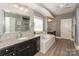 Bathroom features soaking tub, granite countertop vanity, and a large mirror at 10643 Rippling Stream Nw Dr, Concord, NC 28027