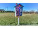 A community 'Little Free Library' box on a post, offering neighborhood book exchange with playground in the background at 10643 Rippling Stream Nw Dr, Concord, NC 28027