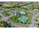 Aerial of community amenities including a pool, tennis courts, clubhouse, and playground at 10643 Rippling Stream Nw Dr, Concord, NC 28027