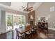 Dining room with a large wooden table and chairs, stone fireplace, and sliding glass doors leading to an outdoor deck at 10643 Rippling Stream Nw Dr, Concord, NC 28027