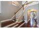 Grand entryway with dark wood floors, staircase with white railings, and arched doorways leading to living areas at 10643 Rippling Stream Nw Dr, Concord, NC 28027