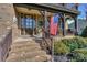 Inviting front porch with brick steps, American flag and a beautifully decorated front door at 10643 Rippling Stream Nw Dr, Concord, NC 28027