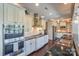 Modern kitchen with stainless steel appliances, white cabinetry, marble countertops, and an elegant chandelier at 10643 Rippling Stream Nw Dr, Concord, NC 28027
