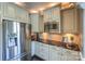 Close up of the gourmet kitchen's stainless steel refrigerator, microwave, and granite countertops at 10643 Rippling Stream Nw Dr, Concord, NC 28027