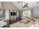 Bright living room featuring large windows, wood floors, and vaulted ceilings with a fan at 10643 Rippling Stream Nw Dr, Concord, NC 28027