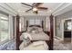 A view of the main bedroom, featuring a four-poster bed, tray ceiling, and sitting area at 10643 Rippling Stream Nw Dr, Concord, NC 28027