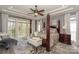 Bright main bedroom suite with large windows, tray ceilings, and a seating area with a bench at 10643 Rippling Stream Nw Dr, Concord, NC 28027