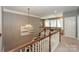 Upstairs hallway with a chandelier and railing overlooking the staircase, offering a view of the home's architecture at 10643 Rippling Stream Nw Dr, Concord, NC 28027