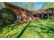 Brick home backyard featuring lush green lawn, multilevel deck, and mature trees at 1213 10Th Street Nw Ln # 3, Hickory, NC 28601