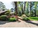 Home exterior features a red brick path, mature trees, and vibrant azaleas at 1213 10Th Street Nw Ln # 3, Hickory, NC 28601