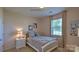 This bedroom has a large window providing ample natural light, as well as a nightstand and end table at 127 Way Cross Ln, Troutman, NC 28166