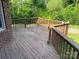 Outdoor deck with wood railings offers a relaxing space with lush greenery and a glimpse of the home's exterior at 1300 Irish Potato Rd, Concord, NC 28025