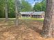 Brick home with a charming front porch and a spacious lawn with mature trees surrounding it at 1300 Irish Potato Rd, Concord, NC 28025