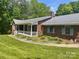 A well-kept brick home with a welcoming front porch, complemented by landscaped surroundings at 1300 Irish Potato Rd, Concord, NC 28025