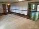 Open living room featuring neutral carpet, wood trim, and seamless transition to a wood-floored area at 1300 Irish Potato Rd, Concord, NC 28025