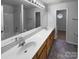 Bathroom featuring double sinks, wood cabinets, a large mirror, and tile flooring at 1325 Crandon Dr, Charlotte, NC 28216