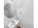 Half bathroom featuring a classic pedestal sink, oval mirror, and neutral decor at 1325 Crandon Dr, Charlotte, NC 28216
