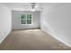 Bedroom with a ceiling fan, neutral paint, carpet, and a large window at 1325 Crandon Dr, Charlotte, NC 28216