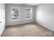 Cozy bedroom featuring neutral carpet, two windows, and ample space at 1325 Crandon Dr, Charlotte, NC 28216