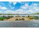 Large grassy backyard with mature trees leads down to the lake with homes lining the opposite shore under a cloudy blue sky at 139 Little Indian Loop, Mooresville, NC 28117