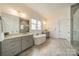 Bright bathroom with dual vanities, a soaking tub, and a glass-enclosed shower for a spa-like experience at 139 Little Indian Loop, Mooresville, NC 28117