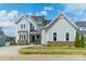 Charming two-story gray home with brick accents, an inviting front porch, and lush landscaping at 139 Little Indian Loop, Mooresville, NC 28117
