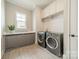 Well-lit laundry room with front load washer and dryer and extra storage cabinets at 139 Little Indian Loop, Mooresville, NC 28117