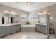 Luxurious bathroom features separate vanities, a soaking tub, a walk-in shower, and elegant finishes at 1519 Cedar Park Dr, Pineville, NC 28134