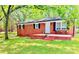 Charming brick home featuring a cozy front porch, black shutters and lovely, mature landscaping at 1780 Short St, Mount Pleasant, NC 28124