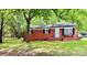 Charming brick home featuring a cozy front porch, black shutters and lovely, mature landscaping at 1780 Short St, Mount Pleasant, NC 28124
