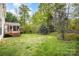 Lush backyard with a deck, screened-in porch, and mature trees providing shade at 1801 Briarcrest Nw Dr, Charlotte, NC 28269