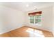Bright bedroom with bamboo floors and a large window adorned with decorative valances at 1801 Briarcrest Nw Dr, Charlotte, NC 28269