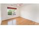 Bedroom with hardwood floors, a ceiling fan, and a window with decorative valances at 1801 Briarcrest Nw Dr, Charlotte, NC 28269