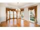 Dining room with hardwood floors, elegant lighting, and beautiful window treatments at 1801 Briarcrest Nw Dr, Charlotte, NC 28269