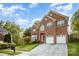Brick two-story house with a two-car attached garage, driveway, and well-manicured front yard with mature trees at 1801 Briarcrest Nw Dr, Charlotte, NC 28269