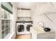Well-equipped laundry room with modern washer and dryer, storage cabinets, and a sink at 1801 Briarcrest Nw Dr, Charlotte, NC 28269
