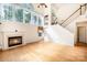 Spacious living room featuring fireplace, hardwood floors, large windows, and staircase at 1801 Briarcrest Nw Dr, Charlotte, NC 28269